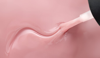 Pink nail polish and brush with wavy pattern