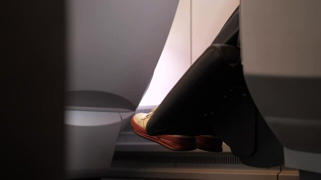 a train passenger in a comfortable carriage folds the seat into a lying position