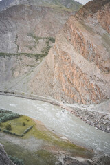 The Panj River flows in the valley Along the Pamir Highway in the mountains of Tajikistan in the morning, a noisy powerful river flows among the rocks