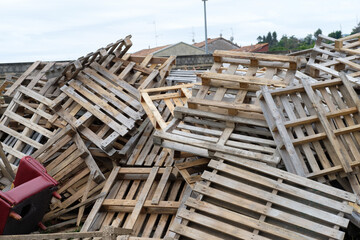 In the image, there is a pile of construction pallets and household items, arranged for burning in the San Juan bonfires.
