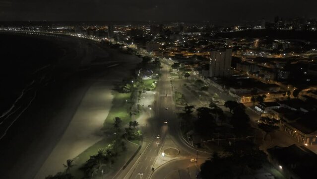 Drone lowers over beachfront highway at night