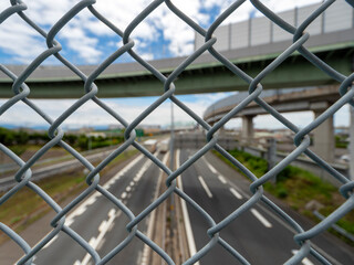 フェンス越しに見る高速道路の風景