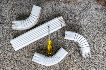 Sections of rectangular metal downspout drain pipe taken apart to clean out clogs blocking water...