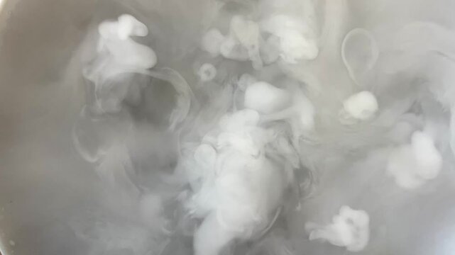 Swirling smoke or steam creating abstract patterns on a gray background