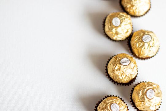 Ferrero Rocher Wrapped Candy in gold on white background border