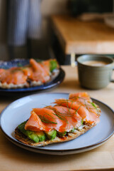 Sourdough toasted with smoked salmon for a healthy and elegant meal on wooden table with a coffee cup food blogs, cooking or culinary guides.