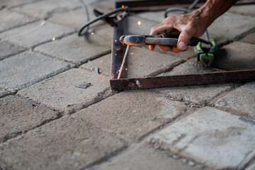 Close-up of welding metal rods on a paved surface