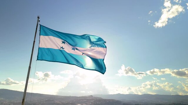 Flag of Honduras with the sun in the background in a sunset
