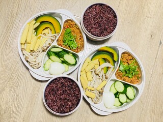 Mixed chili paste and boiled vegetables for packing to take to work, packed in a curved box.