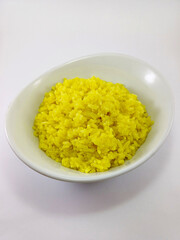 Nasi Kuning, Indonesian Yellow Rice in a White Cup Against a White Background
