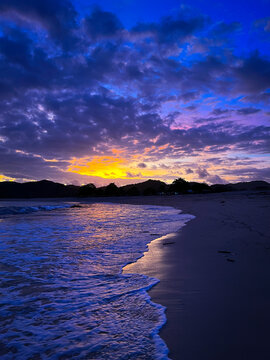Beautiful sunset view at Mawun Beach, Lombok, with dramatic clouds and vibrant colors reflecting on the waves. Perfect for travel, nature, and beach themes.