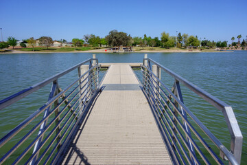 Fototapeta premium Double sided boat dock stretching into cool spring waters of Kiwanis park lake, Tempe, Arizona