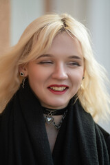 Portrait of a young beautiful blonde girl in a dark coat.