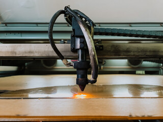 Close up digital die cutter machine cutting corrugated cardboard box for packaging. Industrial manufacture.