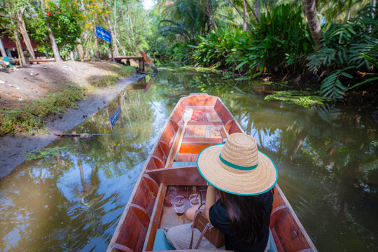 Beautiful asian woman travel on wooden boat in floting market tropical forest river travel