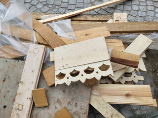 Wooden remains from new carved platbands and other construction debris are lying on the sidewalk.