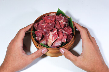 Bamboo baskets with banana leaves serve beef and goat and are held in two hands