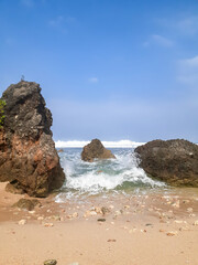 Dynamic Shoreline Symphony: Rocks Embraced by the Ebb and Flow of Crashing Waves