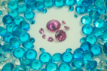 A group of Pink diamonds arranged in the middle of blue diamonds in a white background.Diamonds are highly valued as expensive pieces of jewelry..The sparkling light of the diamonds is beautiful..
