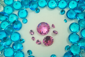 A group of Pink diamonds arranged in the middle of blue diamonds in a white background.Diamonds are highly valued as expensive pieces of jewelry..The sparkling light of the diamonds is beautiful..