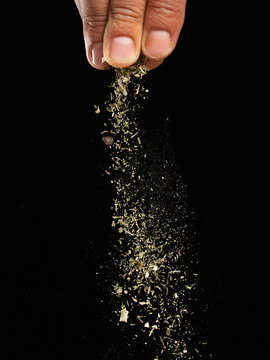 Spices are sprinkled on a dark background