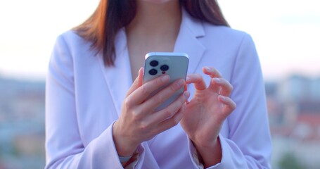 Fototapeta premium No face woman using smartphone. Phone in hands highlighting technology and modern lifestyle. Sense of connectivity, efficiency, and adaptability humans in the digital era. 