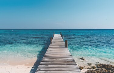 Fototapeta premium A wooden dock extending out into a calm blue sea.
