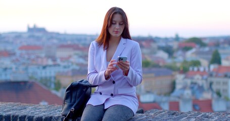 Woman using smartphone against urban backdrop. Technology and modern lifestyle. Sense of connectivity, efficiency, and adaptability humans in the digital era. AI chat bot assistent using.