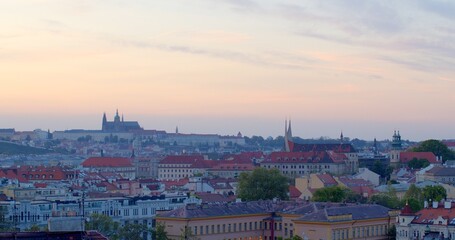 Obraz premium View of Prague from a hilltop. Beautiful European capital city at sunset. Iconic landmarks and historic architecture against the backdrop of colorful sky.