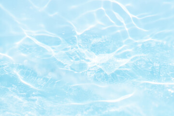 Blue water with ripples on the surface. Defocus blurred transparent blue colored clear calm water surface texture with splashes and bubbles. Water waves with shining pattern texture background.