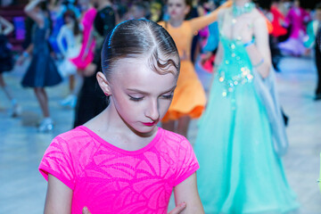 girl with a hairstyle dances before a tournament in ballroom sports dancing at a tournament