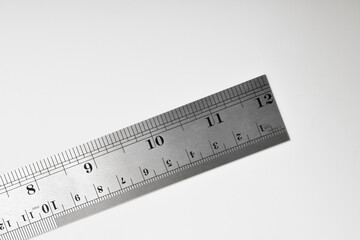 Iron ruler on a white background. Stainless steel ruler. Stationery and work tools made of metal steel. Selective focus, isolated on white background