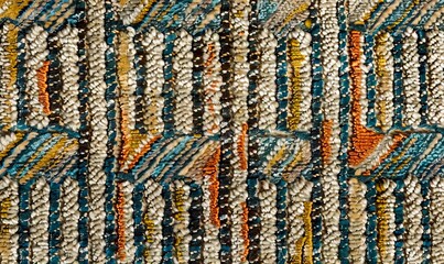 A close up of a rug with a multicolored pattern.