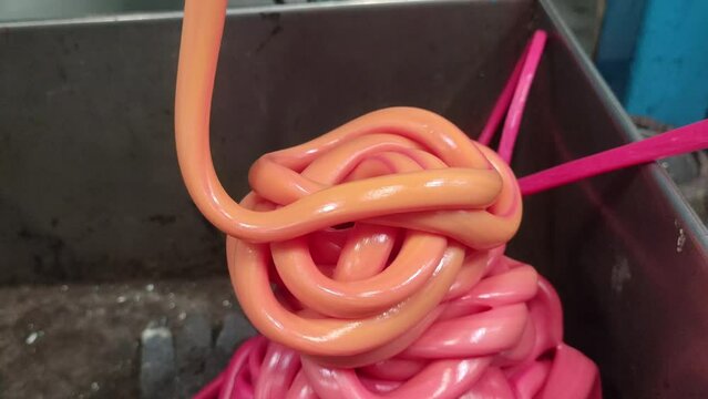 Material Polymers orange and red plastic rubber polyethylene melted being pipe