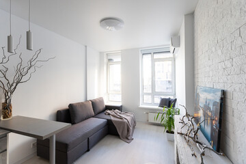 Interior of the modern loft kitchen-studio in the apartment. Room, furniture, sofa near wooden fireplace