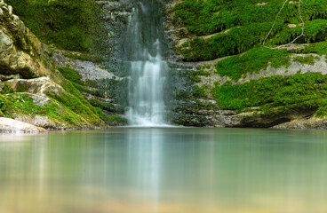 Naklejka premium Beautiful waterfall in the forest in the park