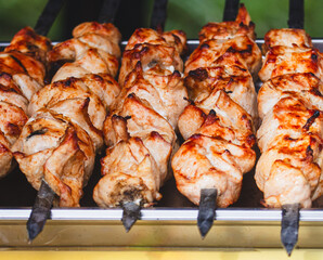 Meat is fried on skewers over coals on a grill