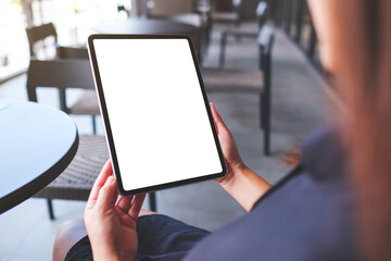 Mockup image of a woman holding digital tablet with blank white desktop screen in cafe
