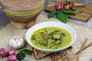Gulai kambing or Indonesian traditional lamb curry, popular Indonesian food special in hari raya made from lamb meat, spices, and coconut milk. grey rustic background.