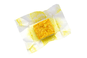 Bouillon cube in unwrapped package, isolated on white, top view. Unwrapped bouillon cube isolated on white background, top view. Condiment in the form of a yellow bouillon cube.