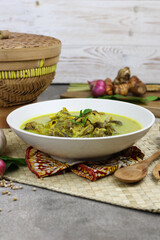 Gulai kambing or Indonesian traditional lamb curry, popular Indonesian food special in hari raya made from lamb meat, spices, and coconut milk. grey rustic background.