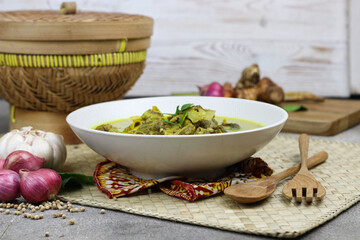 Gulai kambing or Indonesian traditional lamb curry, popular Indonesian food special in hari raya made from lamb meat, spices, and coconut milk. grey rustic background.