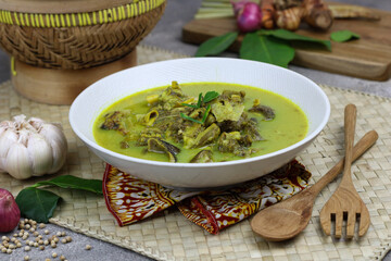Gulai kambing or Indonesian traditional lamb curry, popular Indonesian food special in hari raya made from lamb meat, spices, and coconut milk. grey rustic background.