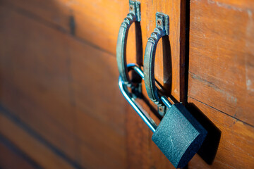 Padlock securing wooden door handles