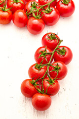 Ripe cherry tomatoes on white wooden background. Close-up of cherry tomatoes.