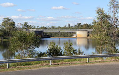 View of Fred Haigh Dam with water, a bridge and trees at Lake Monduran in Queensland, Australia