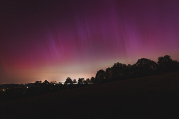 Pink, yellow and red aurora dancing over the Czech Republic. A great solar storm. Night sky under a geomagnetic storm turning pink. A miracle in the Czech Republic. Northern lights