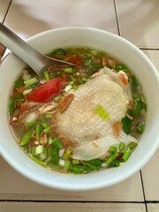 Thai spicy chicken soup in white bowl, local food in Thailand.