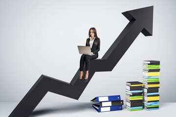 A professional woman with a laptop sitting on an upward arrow next to stacks of colorful books, on...