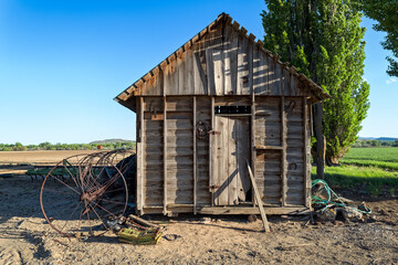 An old wood storage shed stands near the fields on a farm in eastern Oregon, USA